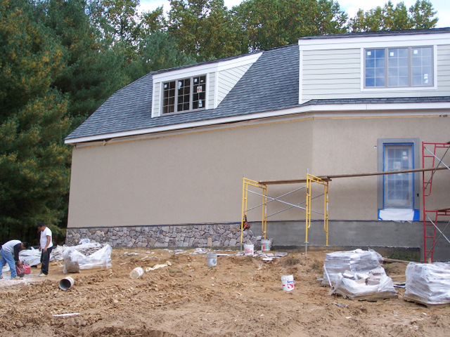 Exterior HardiPlank Siding Installed, Stone Foundation Work Commences